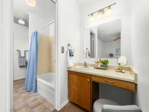 Full bathroom featuring shower / bath combo, vanity, and light tile patterned floors