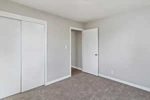 Unfurnished bedroom with a closet and carpet floors