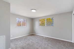 Spare room with light colored carpet and baseboards