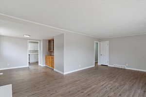 Empty room with light wood finished floors and crown molding