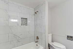 Bathroom with shower / tub combination and wainscoting