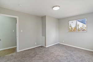 Carpeted spare room featuring baseboards