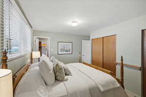 Bedroom with a closet and freestanding refrigerator