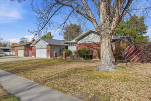 Single story home with brick siding, driveway, and a garage