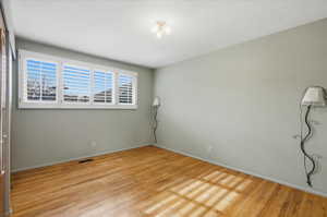 Unfurnished room featuring light wood finished floors and a textured ceiling