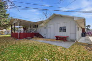 View of front of house with a front yard, stairs, and a wooden deck
