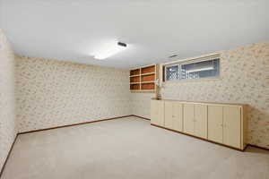 Unfurnished room featuring light carpet and wallpapered walls