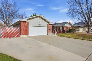 View of front facade featuring brick siding, concrete driveway, and a garage