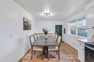 Dining space featuring light tile patterned floors and baseboards
