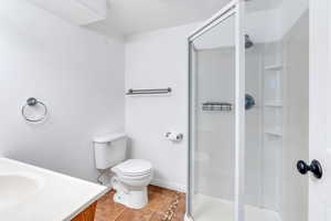 Bathroom with light tile patterned floors, vanity, and a stall shower