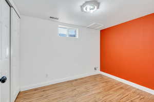 Below grade area with light hardwood floors and baseboards