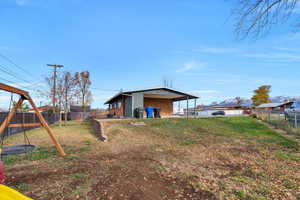Fenced backyard featuring a swing set