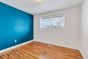 Unfurnished room with hardwood floors and baseboards