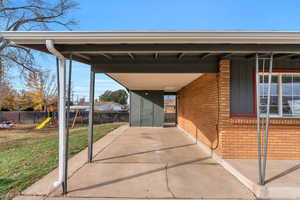 View of parking with a playground and an attached carport
