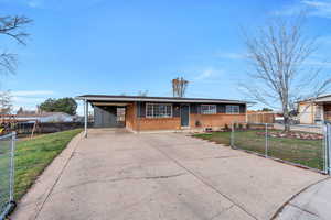 Ranch-style home with brick siding, driveway, and a carport