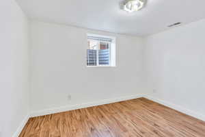 Spare room featuring hardwood floors and baseboards