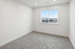 Spare room with light colored carpet, a mountain view, and recessed lighting