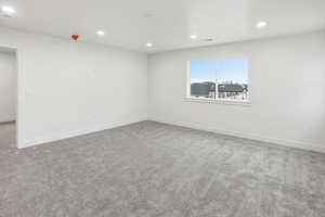 Empty room with recessed lighting and light carpet