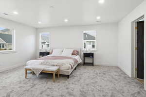 Bedroom with light colored carpet and recessed lighting