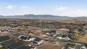 Aerial view of property and surrounding area with mountains and nearby suburban area