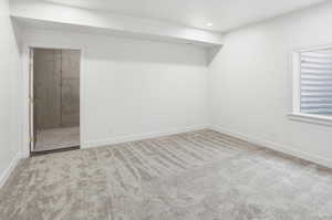 Unfurnished bedroom featuring carpet, ensuite bathroom, and recessed lighting