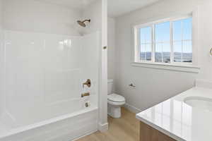 Bathroom with vanity, light wood-type flooring, and shower / washtub combination