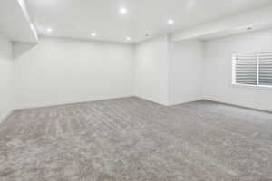 Finished below grade area featuring recessed lighting and light colored carpet