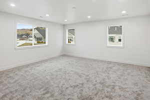 Spare room featuring recessed lighting, healthy amount of natural light, and light colored carpet