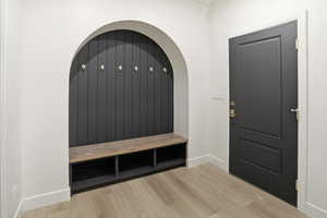 Mudroom featuring light wood finished floors and baseboards