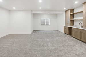 Bar with recessed lighting, open shelves, light colored carpet, light countertops, and light brown cabinetry