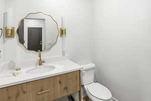 Main floor 1/2 Bathroom featuring toilet and vanity