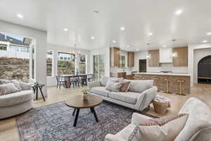 Living area with light wood finished floors, a chandelier, and recessed lighting