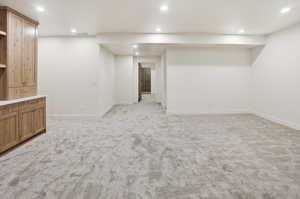 Finished basement with recessed lighting and light colored carpet