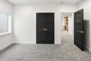 Unfurnished bedroom featuring light carpet and a closet