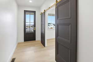 Doorway to outside featuring wood finished floors and a barn door