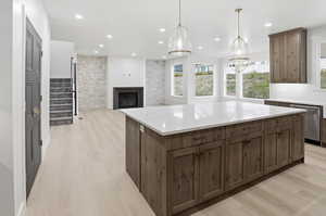 Kitchen with hanging light fixtures, light wood-style flooring, a kitchen island, open floor plan, and recessed lighting
