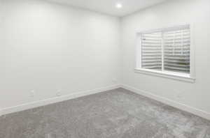 Carpeted spare room featuring baseboards and recessed lighting