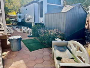 View of patio featuring a storage shed