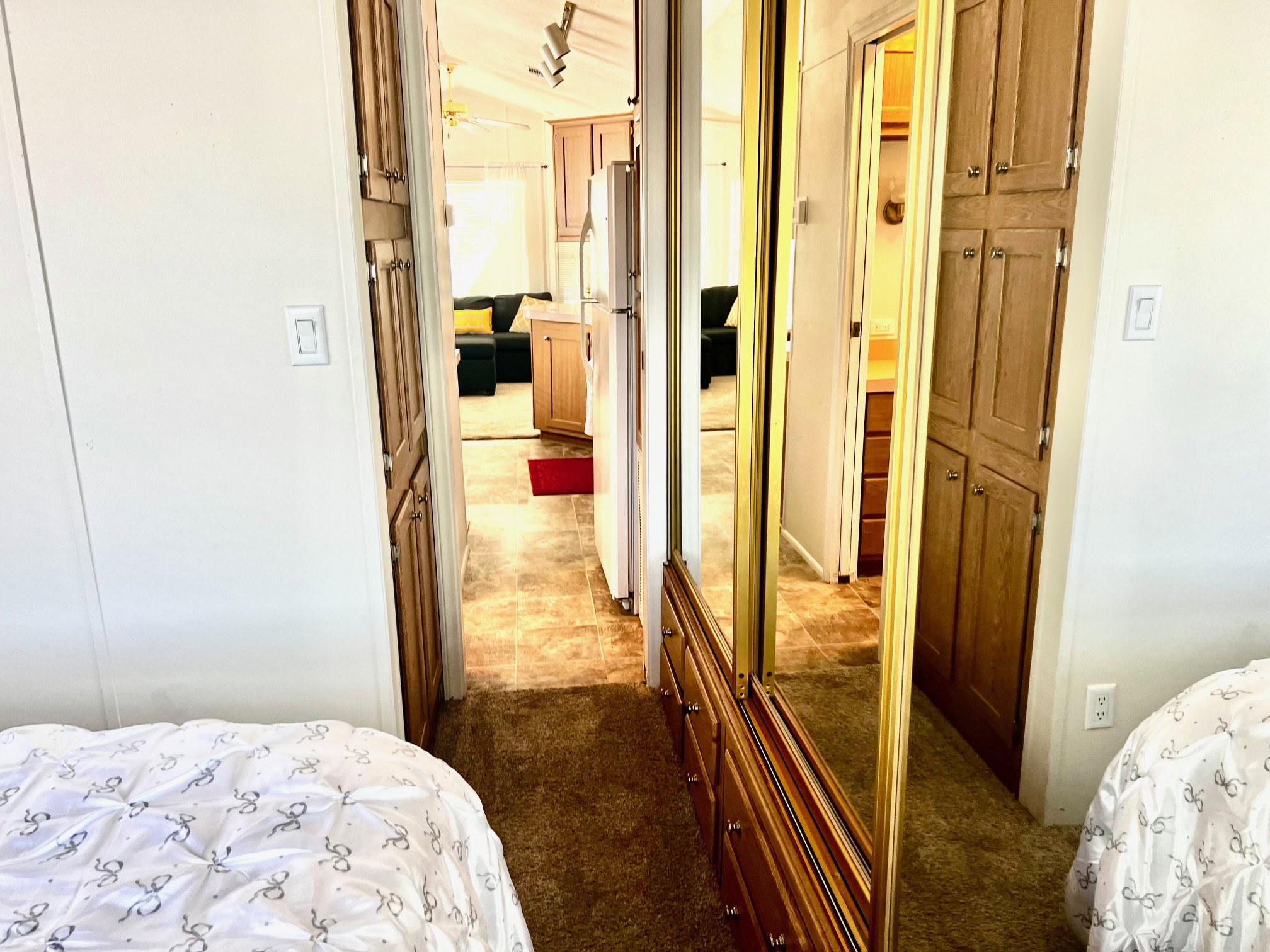 Bedroom featuring freestanding refrigerator, a closet, and dark colored carpet
