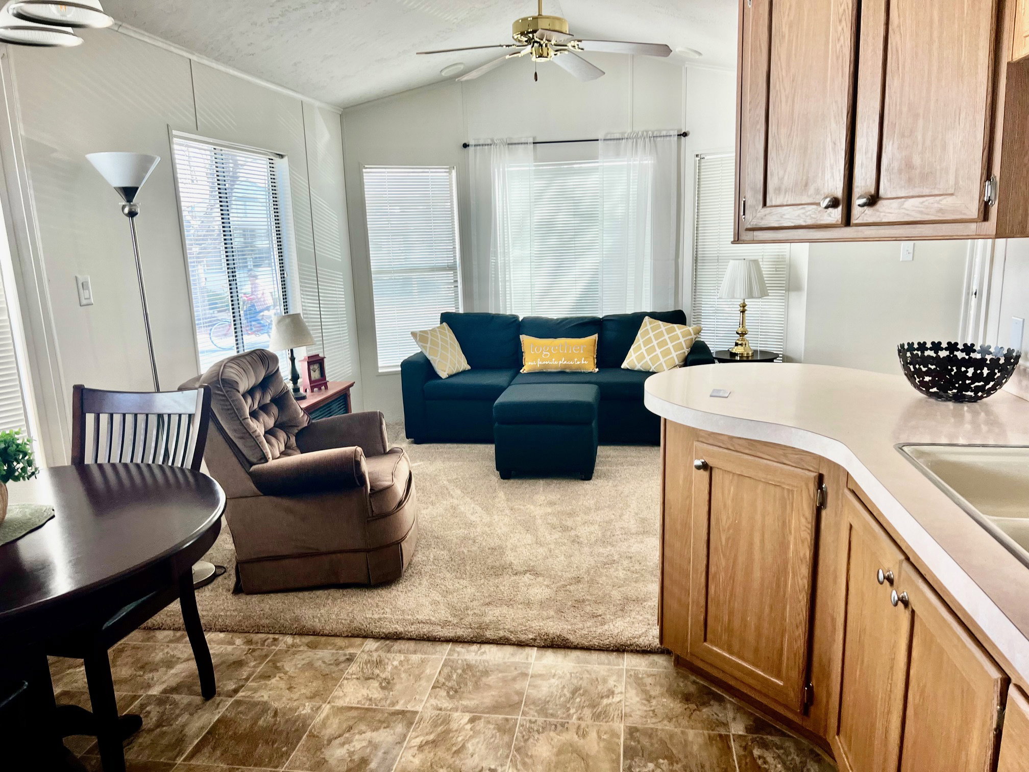 Living room with ceiling fan and lofted ceiling