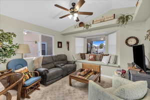 Carpeted living area with lofted ceiling and a ceiling fan