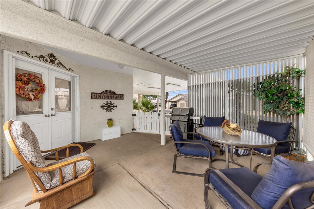 View of patio featuring a gate, outdoor dining space, french doors, and a grill