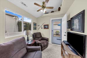 Living area with light carpet and ceiling fan