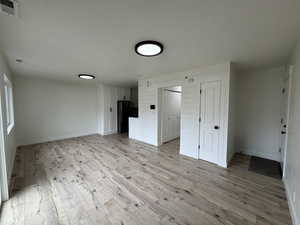 Unfurnished living room with light wood-style flooring and a textured ceiling