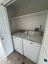Laundry room with light wood-style floors and separate washer and dryer