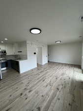 Unfurnished living room featuring light wood finished floors and a textured ceiling