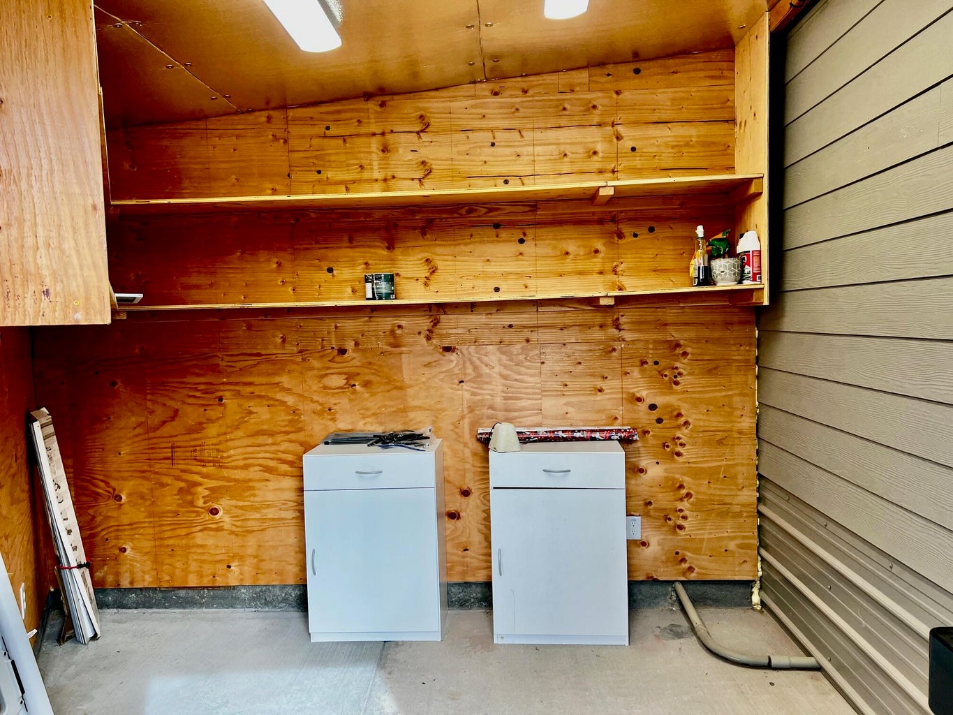 Laundry area featuring wooden walls and vaulted ceiling