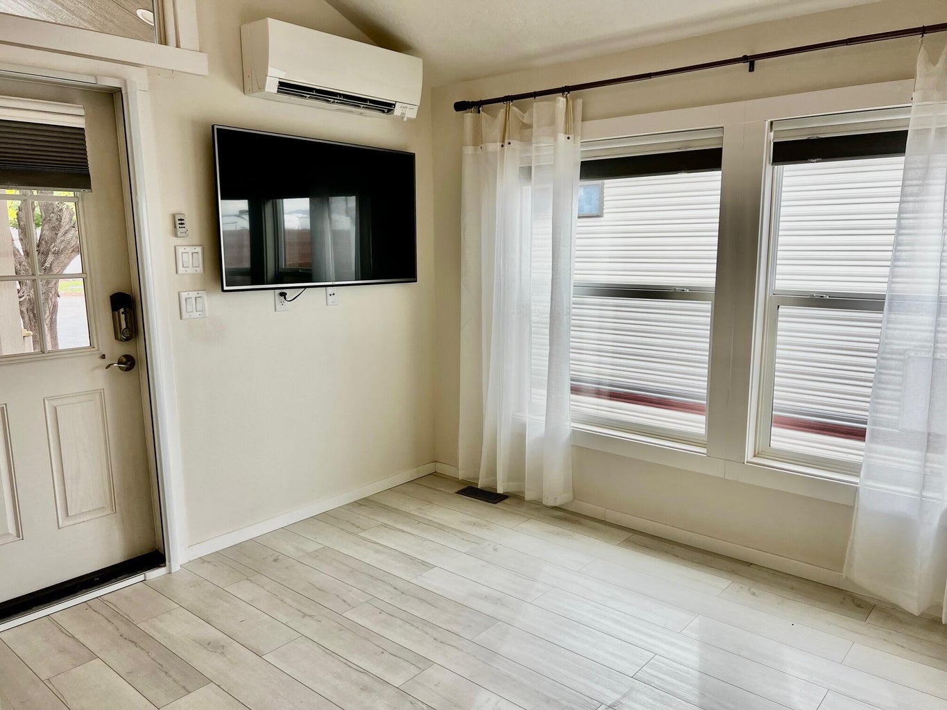Entryway with a wall mounted air conditioner, plenty of natural light, and light wood-type flooring