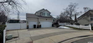 View of side of home featuring concrete driveway, stucco siding, roof with shingles, and an attached 3 car garage