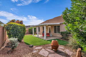 Rear view of house with stucco siding, a patio, a fenced backyard, and a tile roof